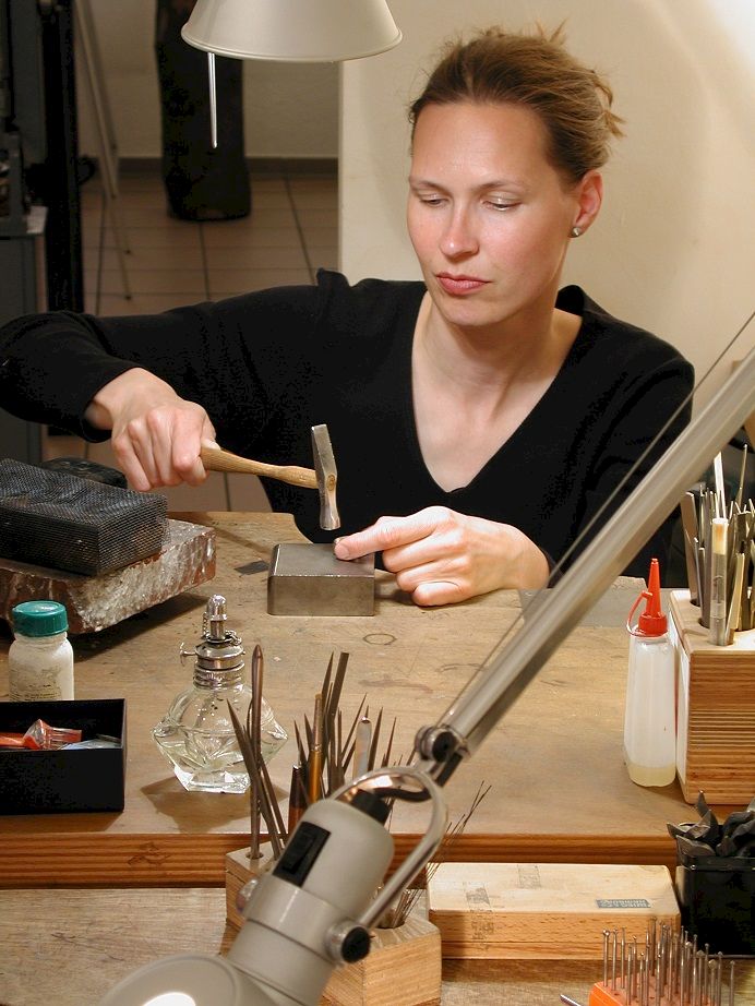 Barbara Kramer goldschmiedend an ihrem Werkbrett
